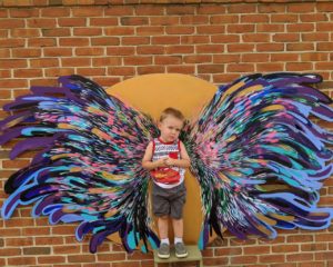 Child posing in front of Fanciful Hummingbird