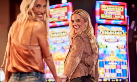 Women standing by a slot machine in rivers Casino Portsmouth